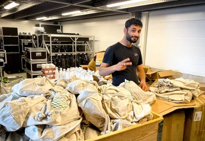 A person packing and preparing materials at a work table.